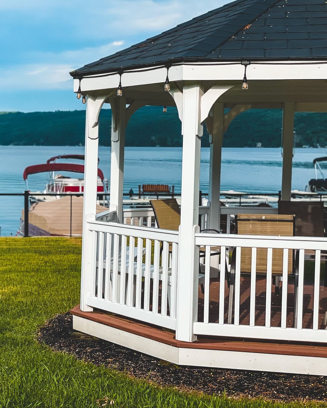 The inn's white gazebo at the water's edge, with boats docked on Keuka Lake behind