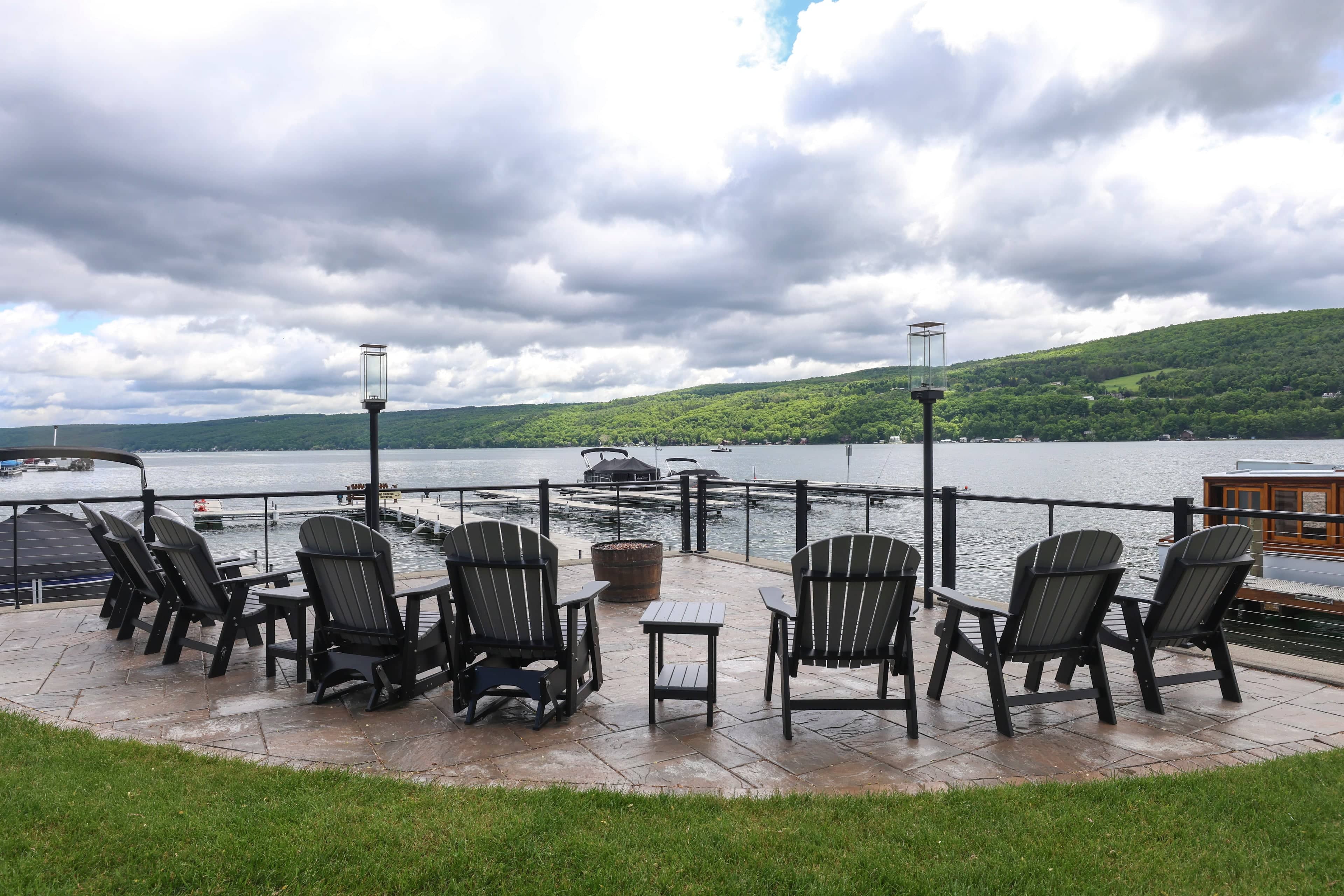 Adirondack chairs around the gas fire pit on the inn's lakeside terrace, the docks and Keuka Lake beyond