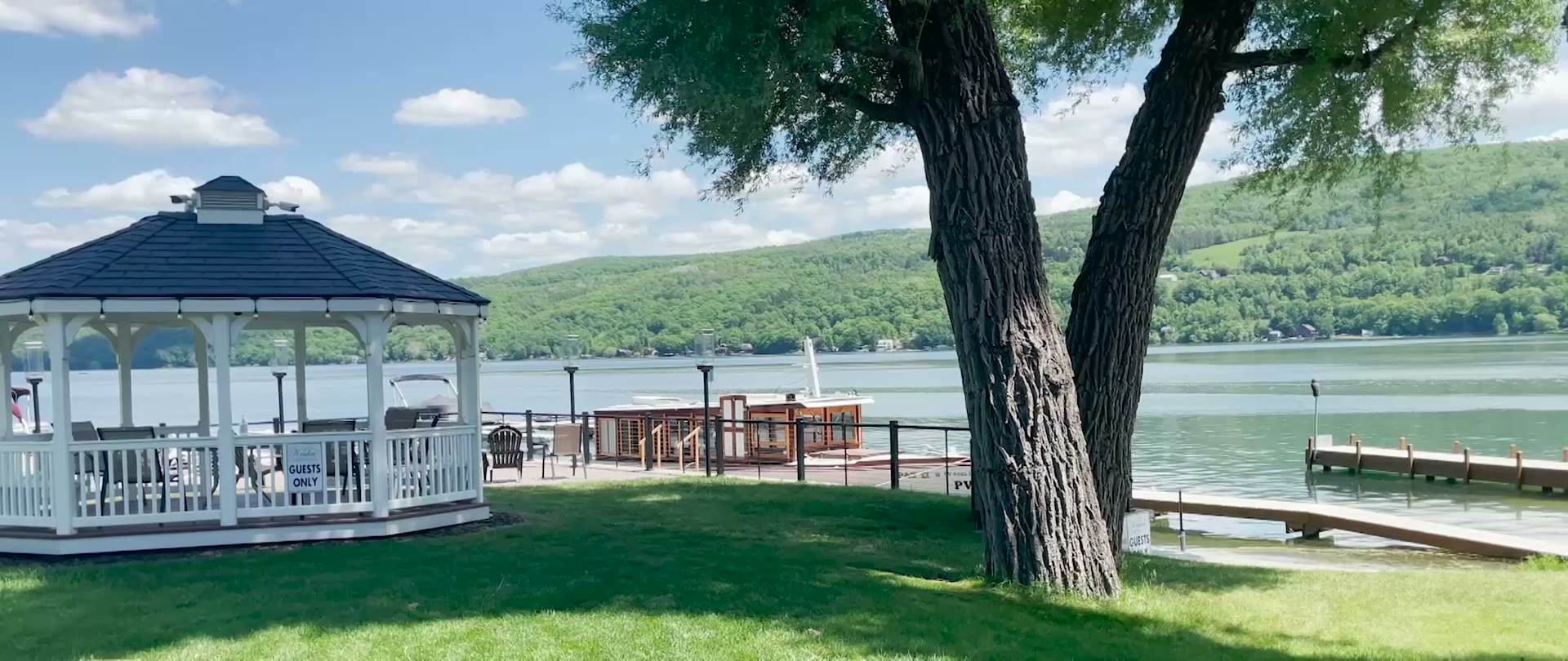 The white gazebo and lawn at the water's edge of Keuka Lake on a bright summer day